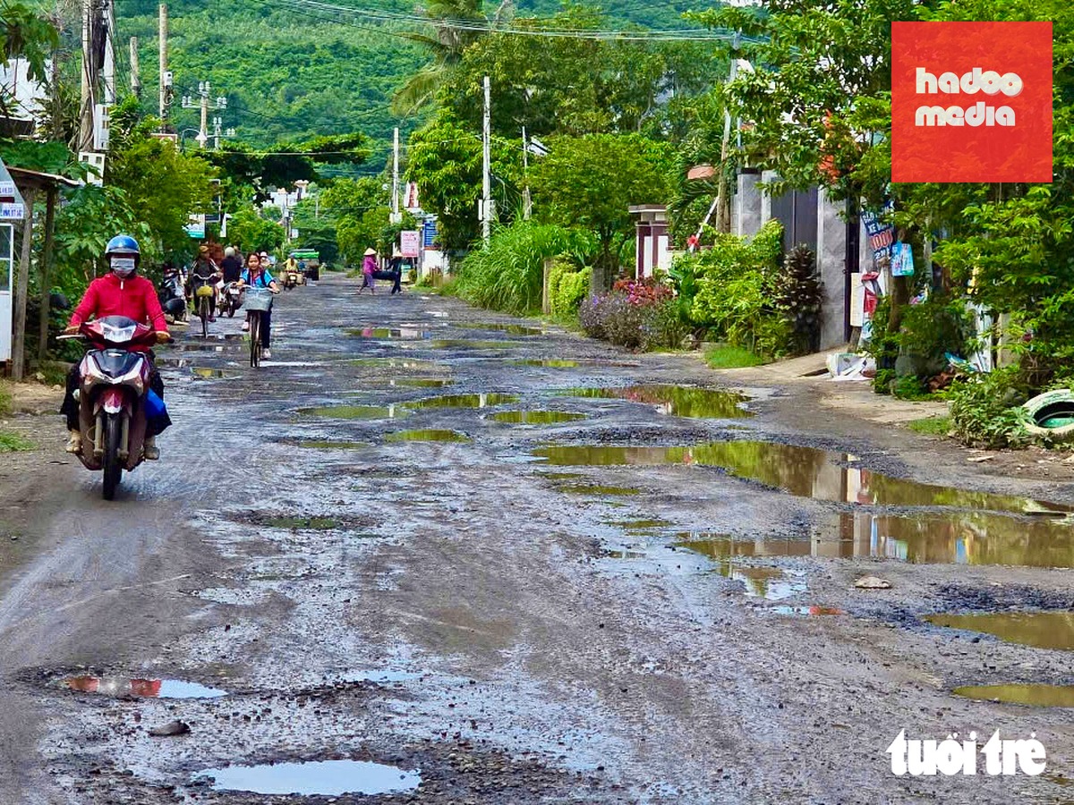 Người dân phải đi sát lề để né ổ gà, ổ voi - Ảnh: MINH CHIẾN