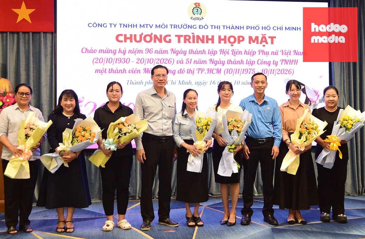 Ông Phan Hồng Thái, Chủ tịch HĐTV Công ty TNHH MTV Môi trường đô thị TP.HCM và ông Cao Văn Tuấn, thành viên chuyên trách HĐTV, Chủ tịch Công đoàn công ty, tặng hoa cho đại diện phụ nữ các chi nhánh - Ảnh: LÊ PHAN