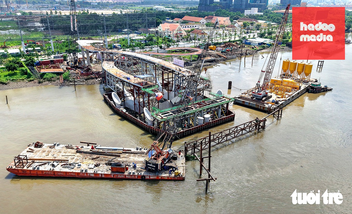 Khu vực thi công nhịp dẫn nối đường Nguyễn Thiện Thành (phường An Khánh, TP.HCM) huy động nhiều cẩu tải hạng nặng, sà lan vận chuyển thiết bị, vật liệu để hỗ trợ hoàn thiện các hạng mục kết cấu nối nhịp chính - Ảnh: THUẬN VĂN