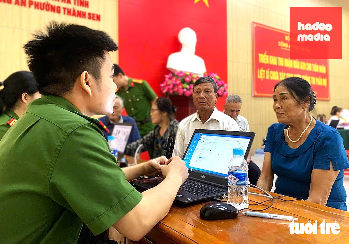 Bà Biện Thị Đông được lực lượng công an hướng dẫn để lấy mẫu ADN - Ảnh: LÊ MINH