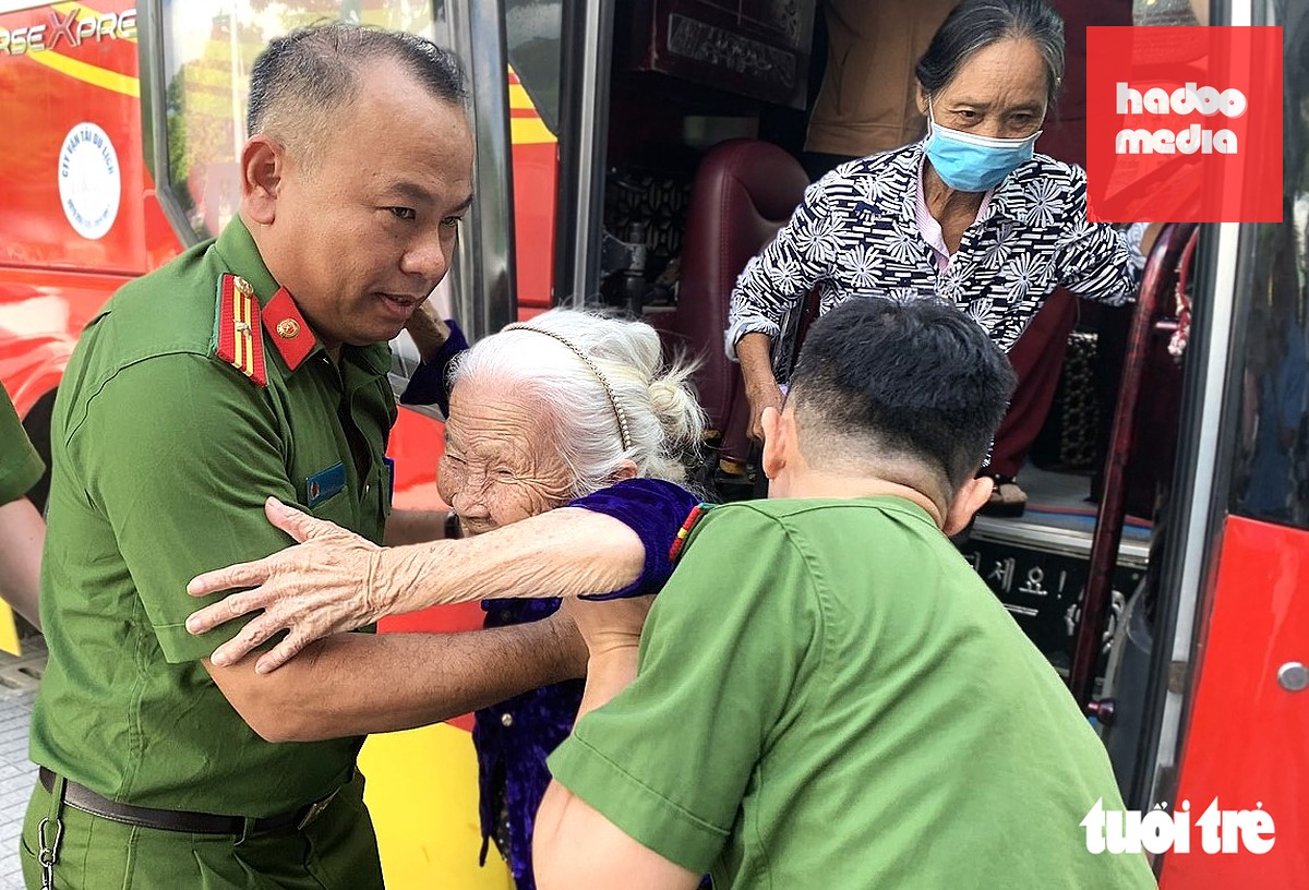 Những người lớn tuổi được lực lượng công an hỗ trợ vào điểm lấy mẫu ADN - Ảnh: LÊ MINH