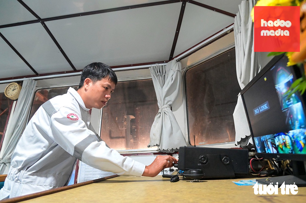 Thuyền trưởng Nguyễn Văn Tâm (tàu VNL 05) tỉ mỉ kiểm tra buồng lái, bộ đàm và các thiết bị liên quan trước khi hợp long - Ảnh: TRÍ ĐỨC