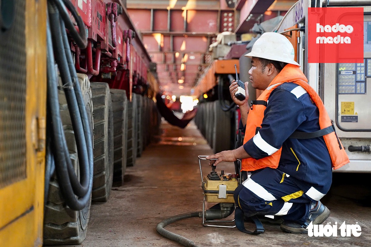 Vào lúc 6h10, không khí làm việc bên dưới sà lan khẩn trương, tất cả các thiết bị, xe nâng hạng nặng sẵn sàng triển khai - Ảnh: THUẬN VĂN