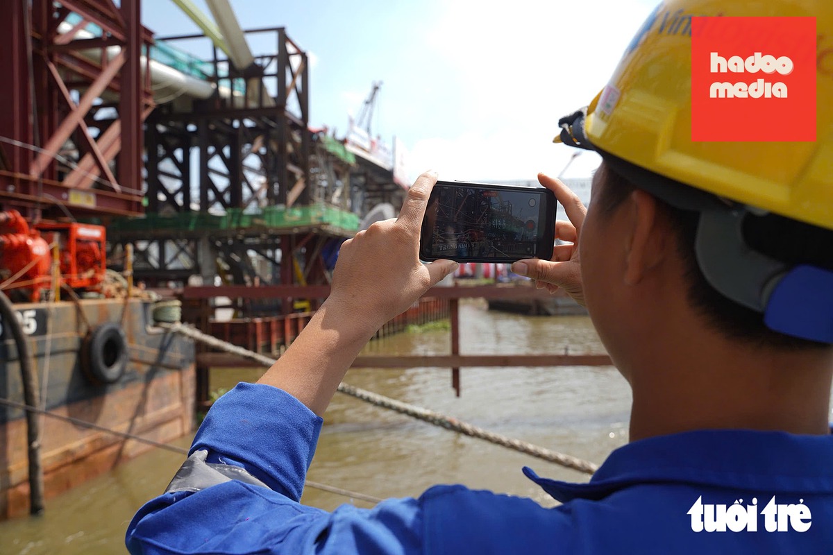 Thành viên tàu lai dắt VNL Future ghi lại khoảnh khắc nhịp chính cầu đi bộ qua sông Sài Gòn chính thức hợp long - Ảnh: THUẬN VĂN