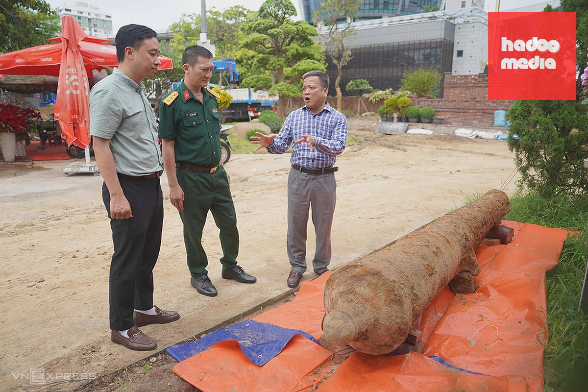 Ông Huỳnh Đình Quốc Thiện (bìa phải) trao đổi với đại diện Bộ Chỉ huy quân sự TP Đà Nẵng về súng thần công vừa phát hiện. Ảnh: Nguyễn Đông