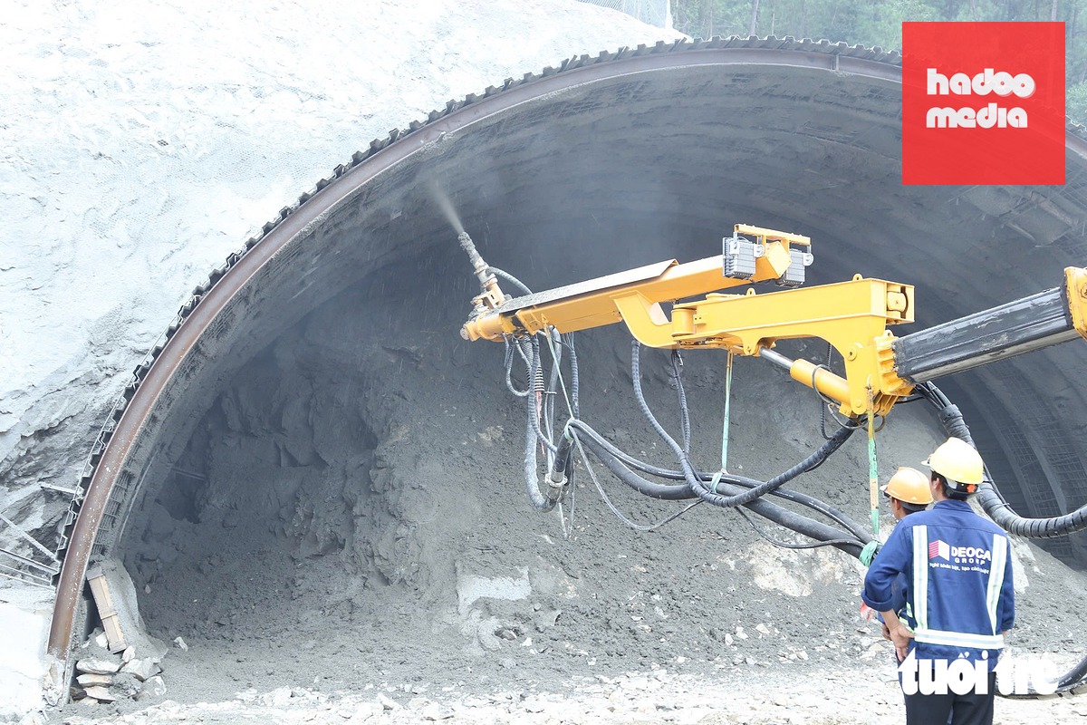 Các lực lượng thi công dựng vỉ, gia cố mái hầm bằng sắt và bê tông - Ảnh: DOÃN HÒA