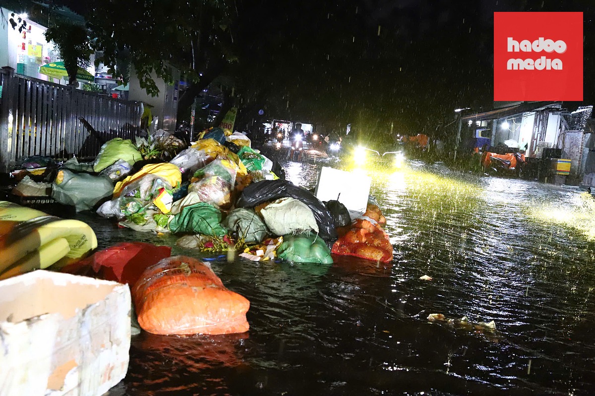 Mưa to, nước lớn cuốn rác trên vỉa hè tại khu chợ Tân Sơn Nhất (phường Hạnh Thông) ra đường - Ảnh: NGỌC LÂN