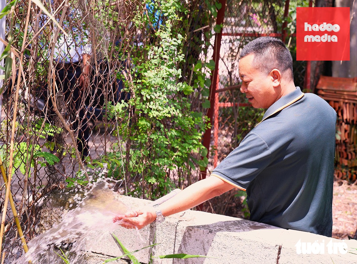 Anh Nguyễn Văn Hùng vui mừng khi dòng nước sạch tuôn chảy, giúp gia đình anh thuận tiện hơn trong sinh hoạt hằng ngày - Ảnh: CAM LY