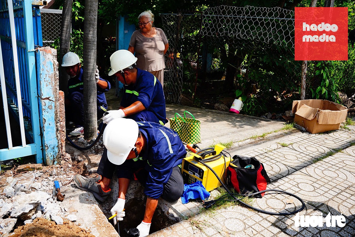 Nhân viên cấp nước thi công lắp đặt đồng hồ nước trực tiếp tại nhà người dân, giúp đưa nguồn nước sạch đến tận hộ gia đình, đáp ứng nhu cầu sinh hoạt hằng ngày - Ảnh: CAM LY