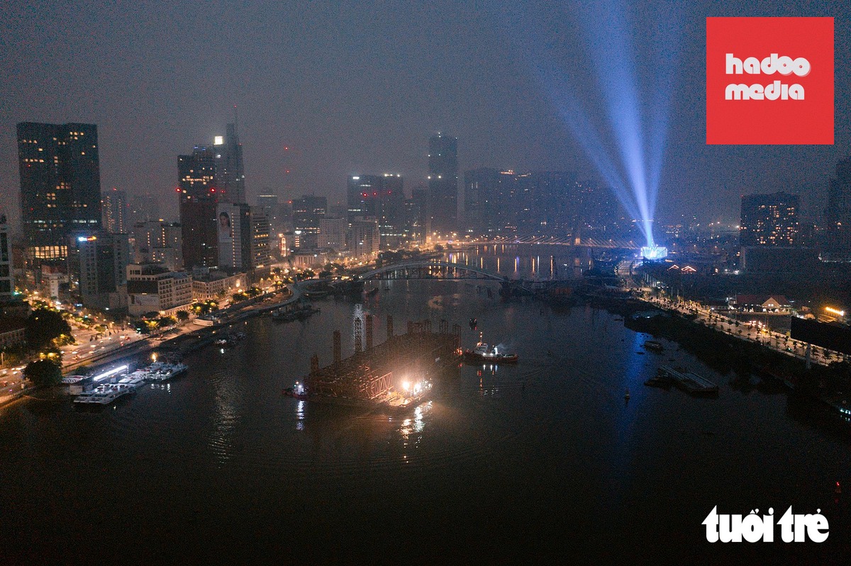 5h sáng 23-10, đoàn tàu lai dắt kéo theo siêu sà lan và hệ khung đỡ tạm biệt trung tâm TP.HCM, trở về Vũng Tàu sau khi hoàn thành hợp long cầu đi bộ qua sông Sài Gòn - Ảnh: HỮU DUY