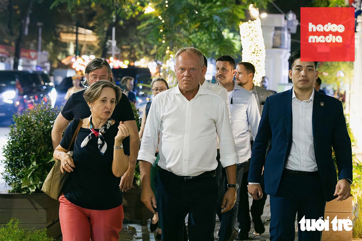 Thủ tướng Ba Lan Donald Tusk (áo trắng) vừa đi vừa trò chuyện với Đại biện lâm thời Đại sứ quán Ba Lan tại Việt Nam, bà Joanna Skoczek - Ảnh: DANH KHANG