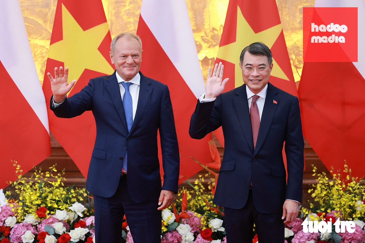 Thủ tướng Lê Minh Hưng và Thủ tướng Ba Lan Donald Tusk vẫy tay chào báo chí trước khi gặp hẹp - Ảnh: NGUYỄN KHÁNH