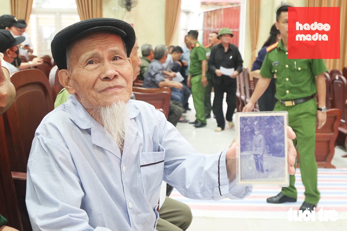 Ông Nguyễn Duy Cuông - 85 tuổi, ngụ xã Xuân Lâm, Nghệ An - mang di ảnh của anh tới điểm thu nhận mẫu ADN thân nhân liệt sĩ sáng 28-10 - Ảnh: DOÃN HÒA