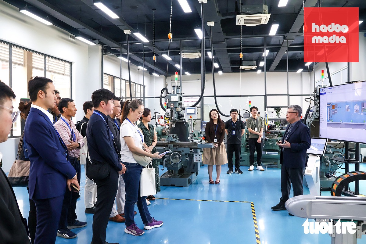Các đại biểu tìm hiểu về các thiết bị công nghệ tân tiến tại Trung tâm Đổi mới sáng tạo công nghiệp 4.0 Việt Nam - Singapore (VSIIC) tại Trường đại học Quốc tế Miền Đông - Ảnh: LONG VŨ