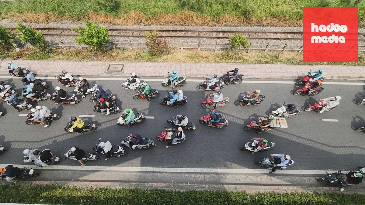 Người dân đứng chờ đèn đỏ dưới bóng râm của cầu bộ hành trên đường Phạm Văn Đồng, phường Thủ Đức, sáng 30/10. Ảnh: Đình Văn